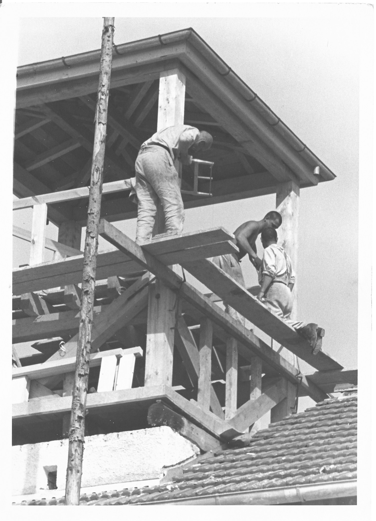 Tre detenuti che lavorano alla costruzione della torre di guardia, in legno, sul Jourhaus, immagine propaganda delle SS (Diritti di immagine: Bundesarchiv)