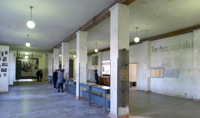 The shunt room is divided down the middle by a row of pillars. The display cases positioned between the pillars are where large wooden tables with file cards once stood for the admission procedure of newly-arriving prisoners.