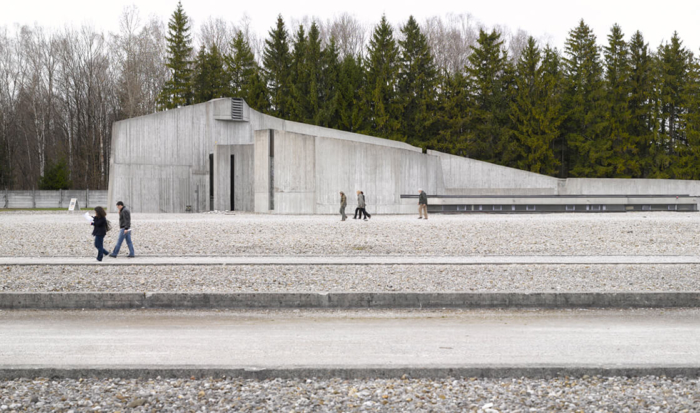 Sunk into the ground, the building made of concrete avoids right angles. On the left, at first a vertical wall arises, which then, at a slight angle, passes into the top of the building. On the other side, this “roof” then, at a gentle trajectory, levels out to the ground.