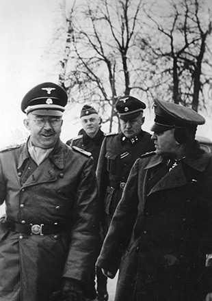 Heinrich Himmler et Theodor Eicke d’humeur joyeuse lors de leur visite au camp de Dachau en 1934, photographie de propagande SS (Crédits photographiques : Archives fédérales allemandes)