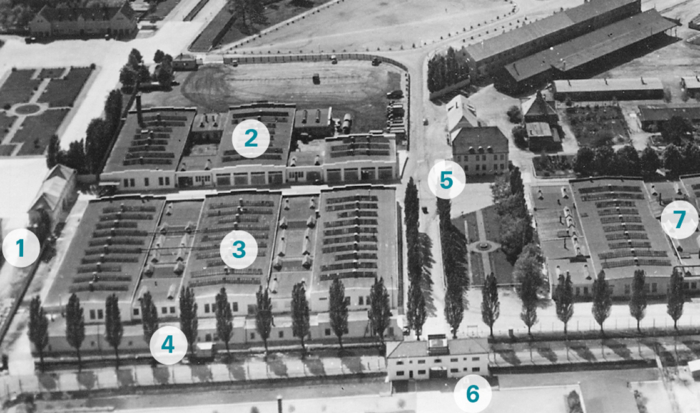 The aerial shot in black and white, which shows a section of the former SS grounds, features numbers designating seven individual building complexes and locations. The adjoining camp grounds are in the lower part of the photo.