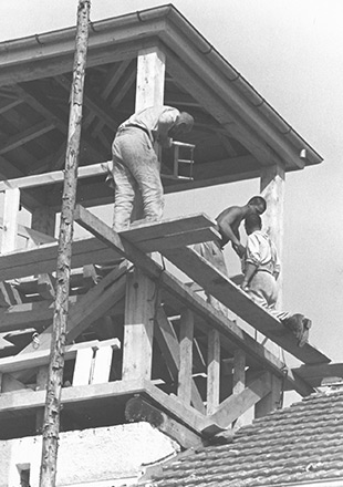 Three prisoners working on the timber frame of the guard tower they were forced to build on the Jourhaus, SS propaganda photo (Bundesarchiv)