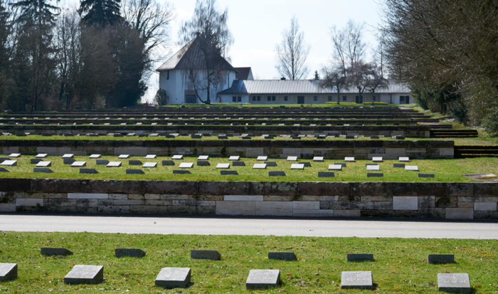 Alcune fosse comuni rialzate sono posizionate in parallelo una dietro l’altra. Lastre di pietra rettangolari sono posizionate per commemorare i defunti.