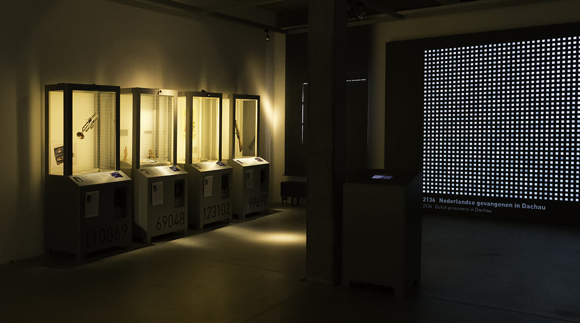 Blick auf vier beleuchtete Ausstellungsvitrinen und das große digitale Schaubild im Sonderausstellungsraum