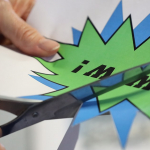 Eine Teilnehmerin schneidet mit einer Schere eine typische Comic-Sprechblase aus