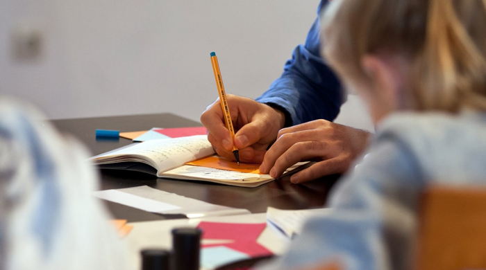 Schülerinnen und Schüler beim schriftlichen Verarbeiten ihrer Eindrücke nach dem Besuch der KZ-Gedenkstätte Dachau