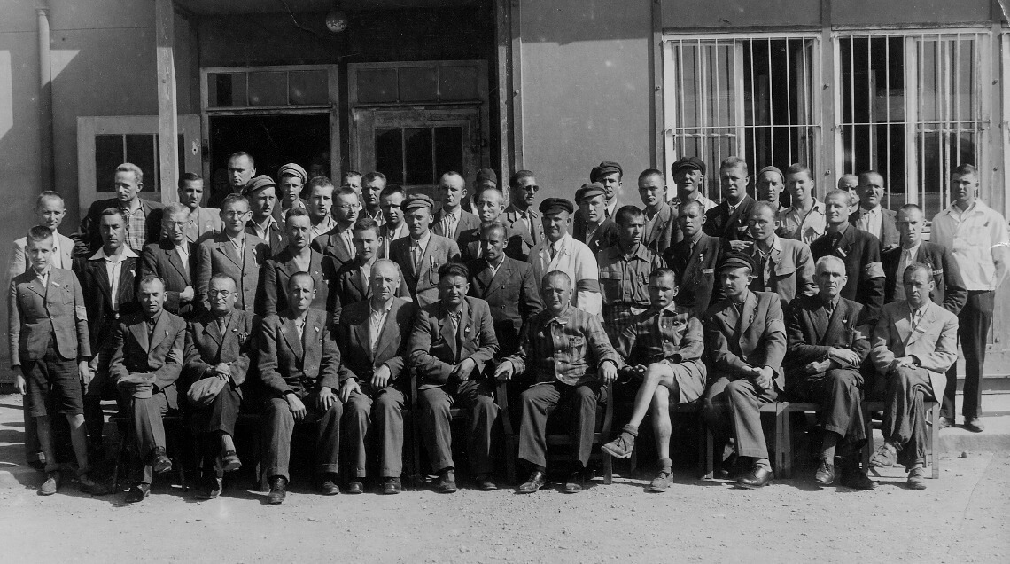 Eine Gruppe befreiter polnischer Häftlinge vor einer Baracke, vermutlich im Mai 1945