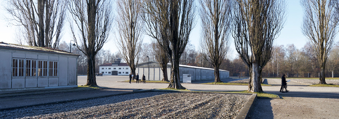 Blick von der ehemaligen Lagerstraße über die beiden Modellbaracken zum ehemaligen Jourhaus