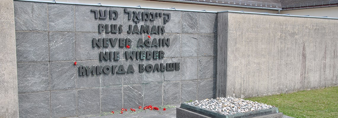 Muro con l'iscrizione „Mai più“ che fa parte del monumento commemorativo internazionale del memoriale del campo di concentramento di Dachau