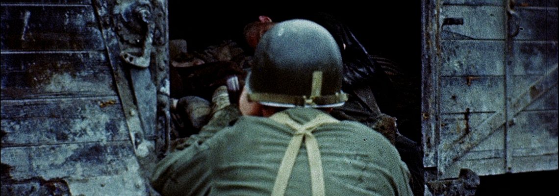 Ein Kameramann des U.S. Army Signal Corps in Dachau, Mai 1945. Aus: [World War II color footage], George Stevens, [Liberation at Dachau] (2. bis 7. Mai 1945). Library of Congress.