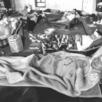 schwarz-weiß Bild der Sinti am siebten Tag ihres Hungerstreiks in den Räumen der Evangelischen Versöhnungskirche,. Alle liegen auf Betten und sehen deutlich geschwächt aus.
