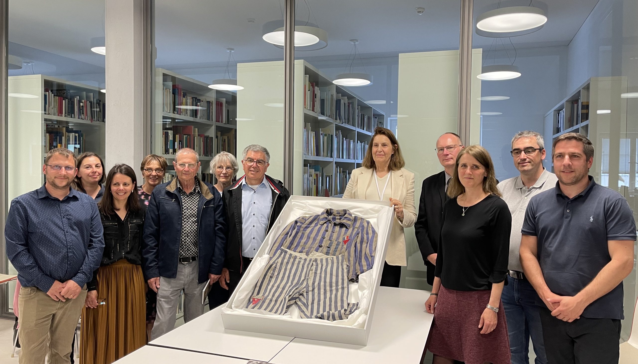 Die Familie Schroeder bei der Kleidungsübergabe, 03.05.2025. Links der Kleidung: Marc und Luc Schroeder (Enkel von Georges Schroeder); rechts der Kleidung: Denis Pfeiffer (Vertreter der Gemeinde Sarreguemines); mittig: Dr. Gabriele Hammermann und Anja Henschel (KZ-Gedenkstätte Dachau).