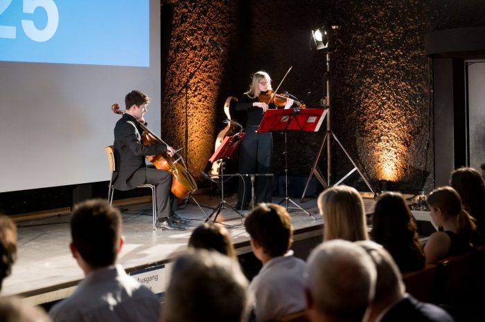 Zwei Personen spielen Violine und Violoncello