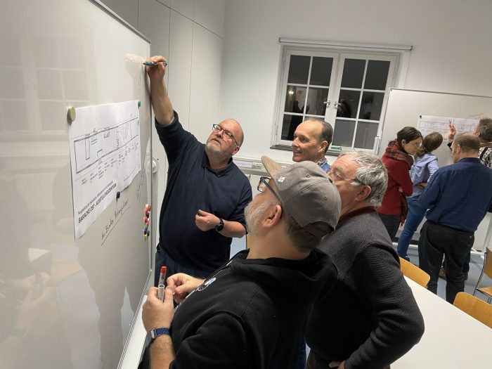 Rundgangsleitungen diskutieren den Neugestaltungsplan der Baracke Ost.